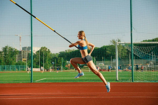 Treinamento feminino de salto alto no estádio em dia ensolarado — Fotografia de Stock