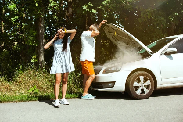 Pareja joven viajando en el coche en un día soleado — Foto de Stock