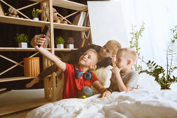 Niños pequeños usando diferentes aparatos en casa —  Fotos de Stock