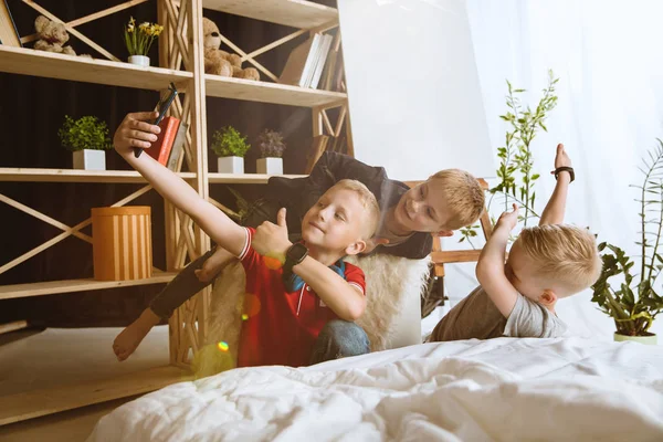 Niños pequeños usando diferentes aparatos en casa —  Fotos de Stock