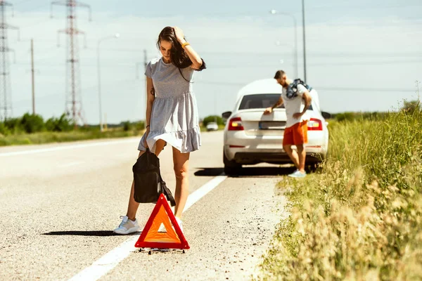Casal jovem viajando no carro em dia ensolarado — Fotografia de Stock