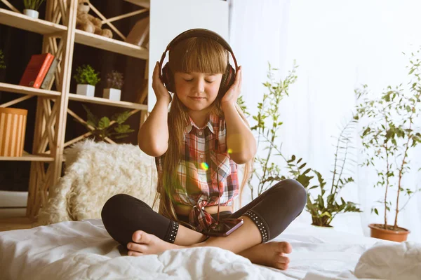 Little girl using different gadgets at home — Stock Photo, Image