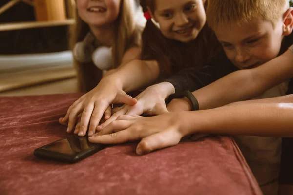 Meninos e meninas usando diferentes gadgets em casa — Fotografia de Stock