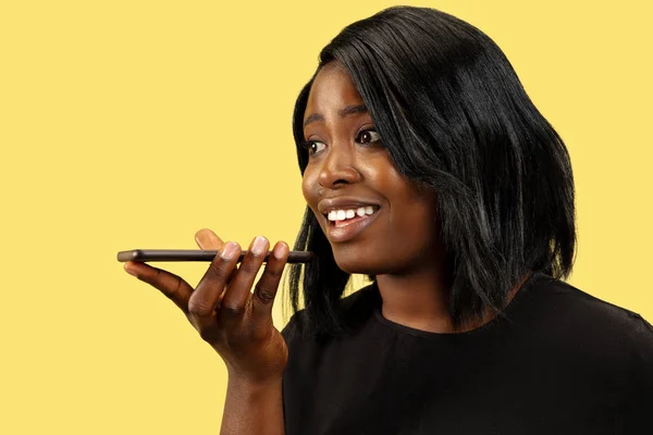 Jonge Afrikaanse vrouw geïsoleerd op gele studio achtergrond, gezichtsuitdrukking — Stockfoto
