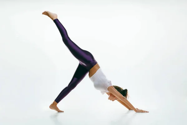 Sportig ung kvinna gör yoga praxis isolerad på vit bakgrund — Stockfoto