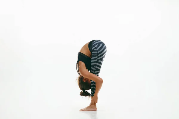 Sportieve jonge vrouw doen yoga praktijk geïsoleerd op witte achtergrond — Stockfoto