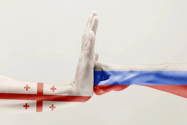 Zwei Hände. Flagge der Russischen Föderation. Flagge von Georgien. — Stockfoto