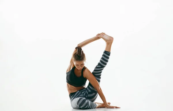 Sportig ung kvinna gör yoga praxis isolerad på vit bakgrund — Stockfoto