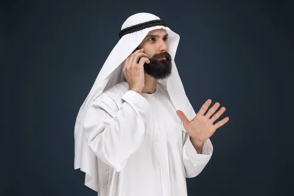 Hombre saudí árabe sobre fondo de estudio azul oscuro — Foto de Stock