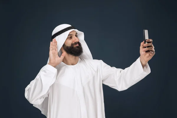 Hombre saudí árabe sobre fondo de estudio azul oscuro — Foto de Stock