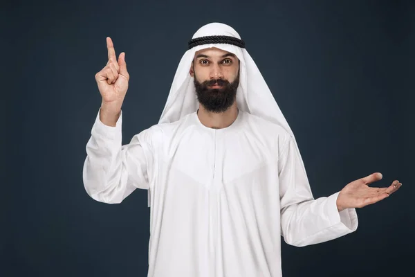 Árabe saudi homem no escuro azul estúdio fundo — Fotografia de Stock