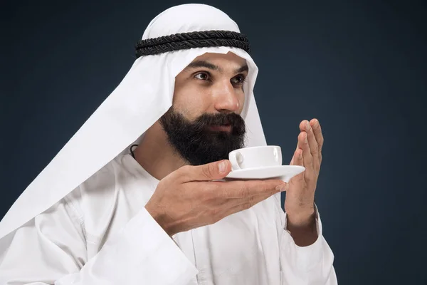 Hombre saudí árabe sobre fondo de estudio azul oscuro — Foto de Stock