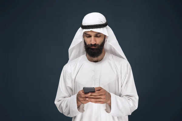 Hombre saudí árabe sobre fondo de estudio azul oscuro — Foto de Stock