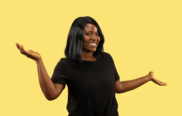 Mujer africana joven aislada sobre fondo de estudio amarillo, expresión facial —  Fotos de Stock