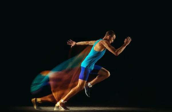 Professionelles Läufertraining isoliert auf schwarzem Studiohintergrund in gemischtem Licht — Stockfoto