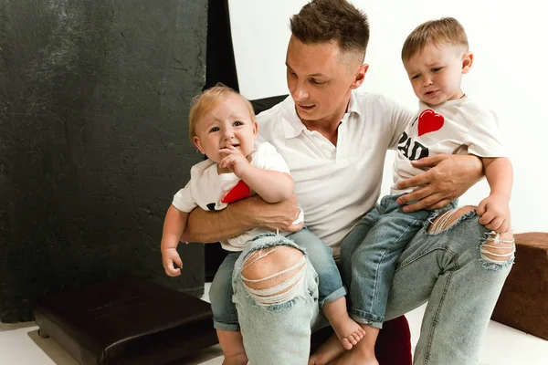 Happy father holding adorable little sons and smiling — Stock Photo, Image