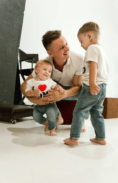 Pai feliz segurando adoráveis filhinhos e sorrindo — Fotografia de Stock