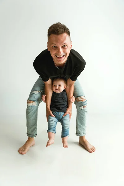 Pai feliz segurando pequeno filho adorável e sorrindo — Fotografia de Stock