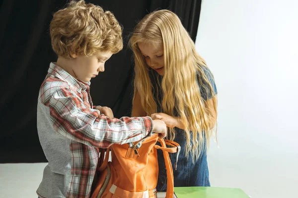 Pojke och flicka förbereder sig för skolan efter en lång sommarlov. Tillbaka till skolan. — Stockfoto