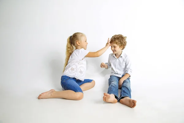 Pojke och flicka som leker tillsammans på vit Studio bakgrund — Stockfoto