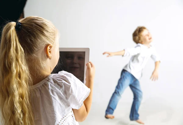 Хлопчик і дівчинка грають разом на білому фоні студії — стокове фото