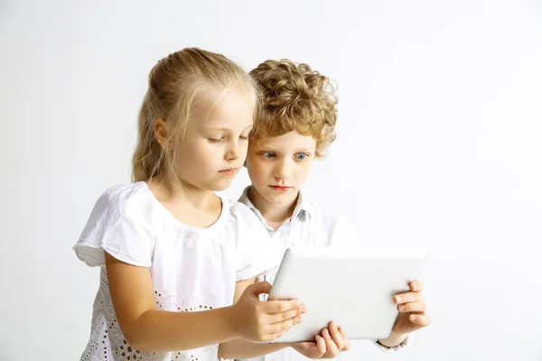 Мальчик и девочка играют вместе на белом фоне студии — стоковое фото