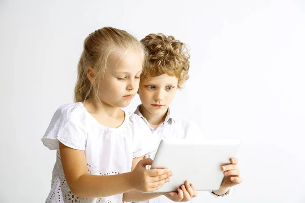 Niño y niña jugando juntos en el fondo blanco del estudio — Foto de Stock