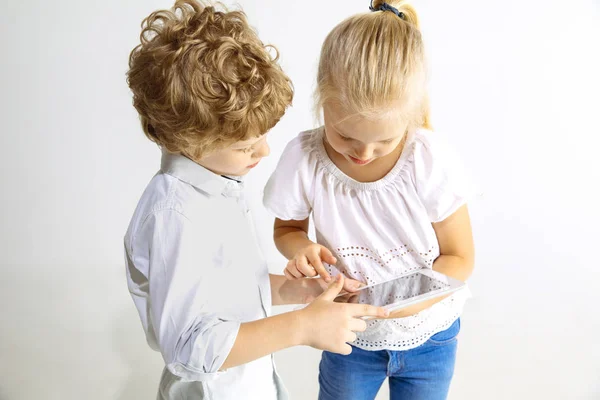 Menino e menina jogando juntos no fundo do estúdio branco — Fotografia de Stock