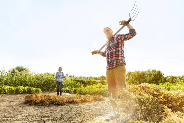Pasangan petani muda dan bahagia di kebun mereka di hari yang cerah — Stok Foto