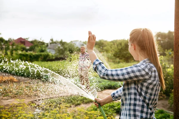 Young and happy farmers couple at their garden in sunny day — Stock Photo, Image