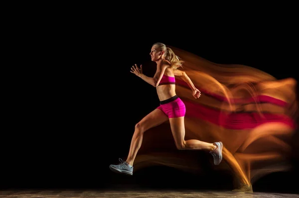 Formazione professionale femminile relè corridore su sfondo nero studio in luce mista — Foto Stock