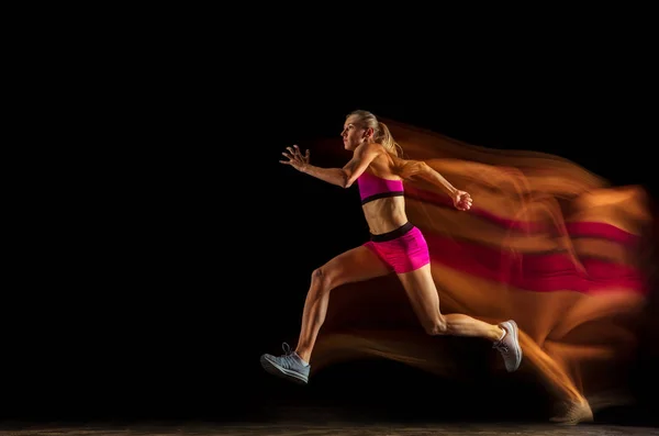 Entrenamiento profesional de relés femeninos sobre fondo de estudio negro en luz mixta — Foto de Stock