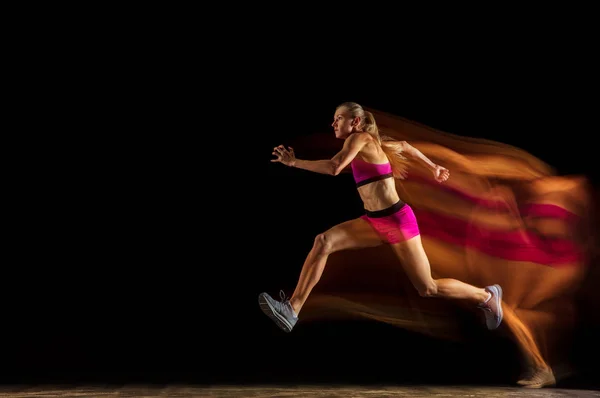 Entrenamiento profesional de relés femeninos sobre fondo de estudio negro en luz mixta — Foto de Stock