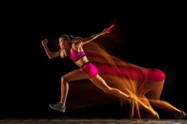 Karışık ışıkta siyah stüdyo arka plan profesyonel kadın röle yarışçı eğitim — Stok fotoğraf