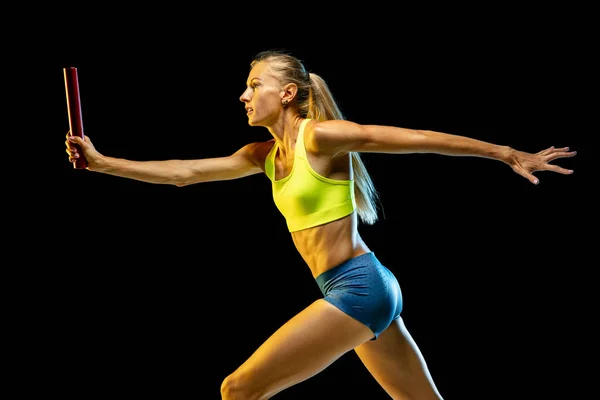 Entrenamiento profesional de relé femenino sobre fondo de estudio negro en luz de neón — Foto de Stock