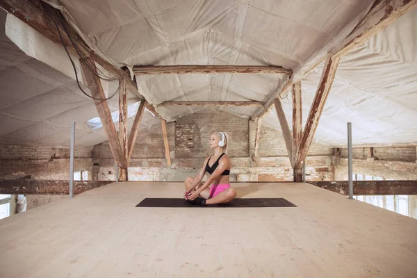 A young athletic woman working out on an abandoned construction site — Stock Photo, Image