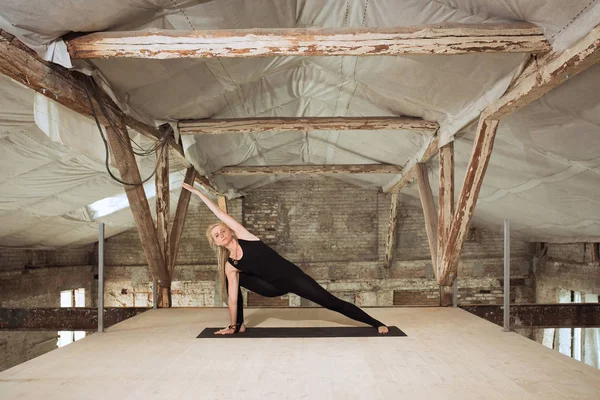 Giovane donna esercita yoga in un cantiere abbandonato — Foto Stock