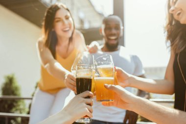 Genç arkadaş grubu bira içip birlikte kutlama yapıyor.