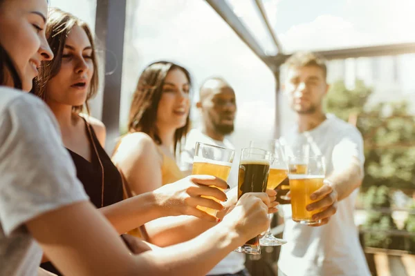 Joven grupo de amigos bebiendo cerveza y celebrando juntos — Foto de Stock