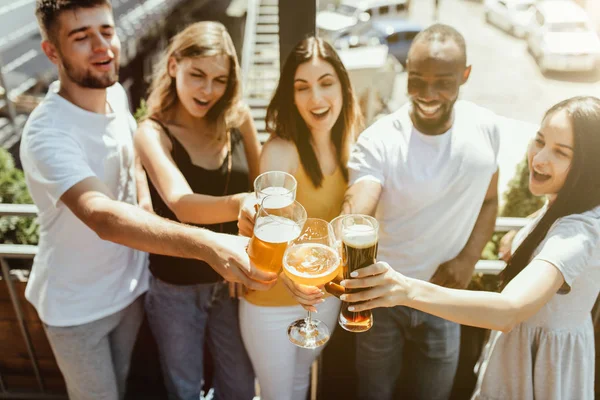 Joven grupo de amigos bebiendo cerveza y celebrando juntos — Foto de Stock