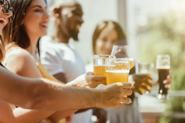 Joven grupo de amigos bebiendo cerveza y celebrando juntos — Foto de Stock