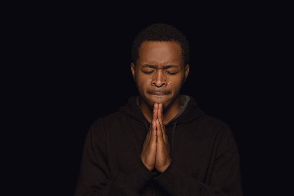 Close up portrait of young man isolated on black studio background