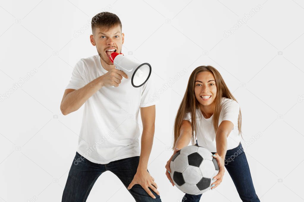 Portrait of beautiful couple football fans on white studio background