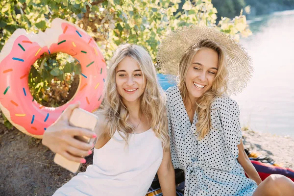 Giovani lesbiche coppia divertirsi e trascorrere del tempo a riva del fiume in giornata di sole — Foto Stock