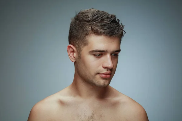 Портрет молодого человека без рубашки, изолированного на сером фоне студии — стоковое фото