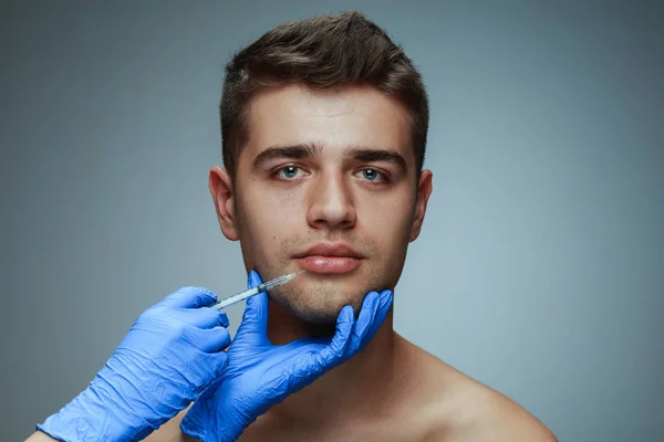 Portrét mladého muže izolovaného na šedém studiovém pozadí — Stock fotografie