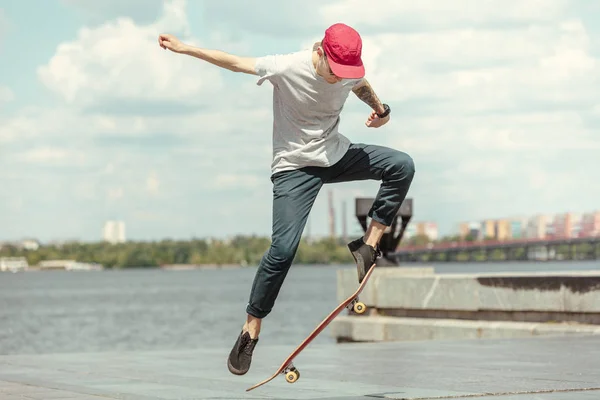 Skateboarder doing a trick at the citys street in sunny day — Stock Photo, Image