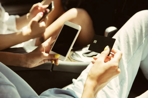 Young lesbians couple preparing for vacation trip on the car in sunny day