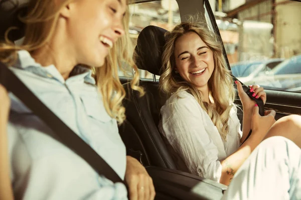 Genç lezbiyençift güneşli bir günde arabada tatil gezisi için hazırlanıyor