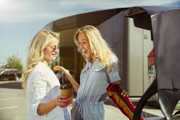 Jóvenes lesbianas se preparan para el viaje de vacaciones en el coche en un día soleado — Foto de Stock